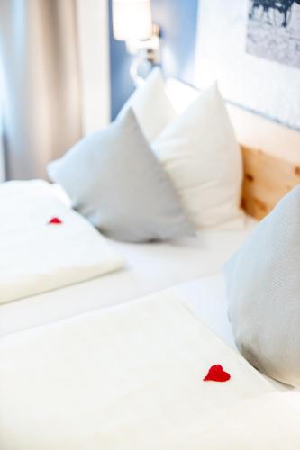 a white bed with pillows and a red heart on it at Kärnten Apartment Turnersee in Sankt Kanzian