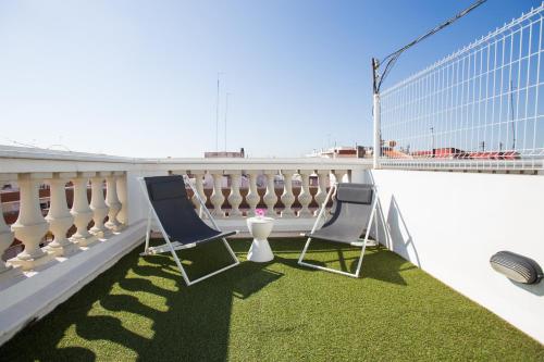 two chairs sitting on a balcony with green grass at Sky Touristic Attic in Valencia