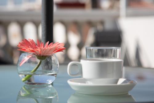 a vase with a flower and a cup on a table at Sky Touristic Attic in Valencia