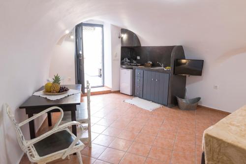 a kitchen with a table and a television in a room at Lotza Studios in Oia