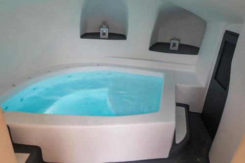a jacuzzi tub in the middle of a room at Lotza Studios in Oia