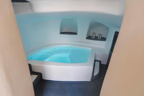 a bathtub in a room with a blue tub at Lotza Studios in Oia