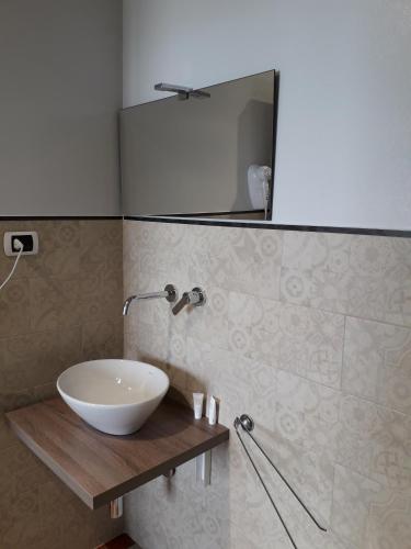 a bathroom with a bowl sink and a mirror at B&B L'Isola in Porto Cesareo