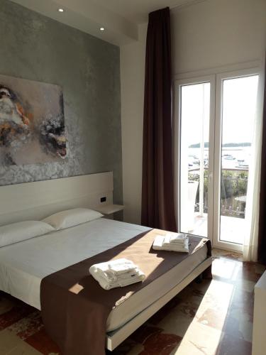 a bedroom with a bed and a large window at B&B L'Isola in Porto Cesareo