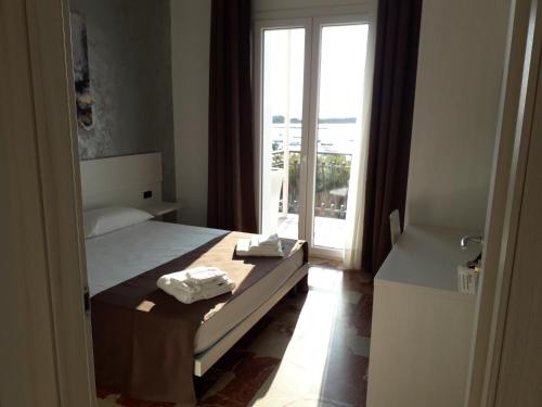 a bedroom with a bed and a door to a balcony at B&B L'Isola in Porto Cesareo