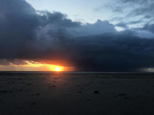 a sunset on a beach with a cloudy sky at FACE A LA MER , L ARTISTE in Ambleteuse