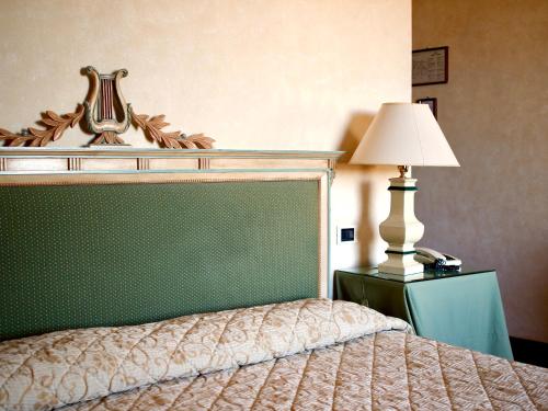 a bedroom with a bed with a lamp on a table at Relais Ducale in Gubbio