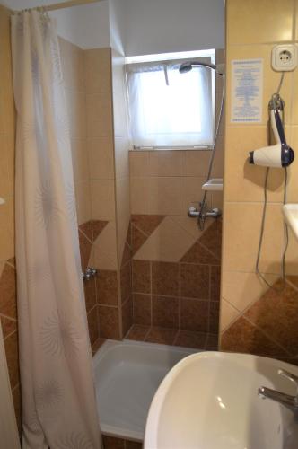 a bathroom with a tub and a sink and a shower at Alfréd Panzió in Budapest