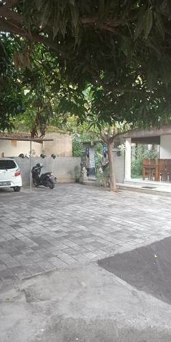 a parking lot with a motorcycle parked next to a tree at Pondok Aldi in Amed