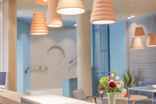 una cocina con una mesa con un jarrón de flores y luces en Hotel Letizia, en Bellaria-Igea Marina