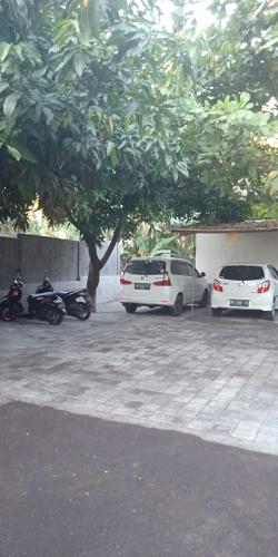 a group of cars parked in a parking lot with a tree at Pondok Aldi in Amed