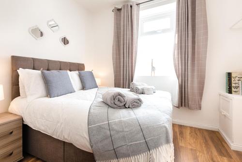 a bedroom with a bed with towels on it at Contractor-Approved - 4 Bed - Smart TVs - Access M4 in Swansea