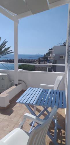 a blue bench and a chair on a balcony at Apostolakis Rooms in Agios Kirykos