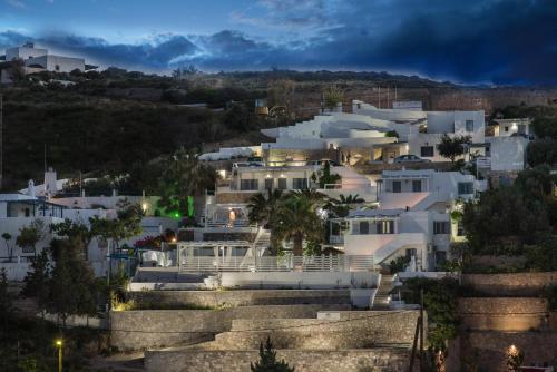 a group of white houses in a city at night at Alexandros Village in Adamas