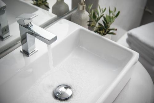 a white sink with a faucet in a bathroom at Alexandros Village in Adamas