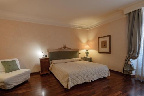 a bedroom with a bed and a chair at Relais Ducale in Gubbio