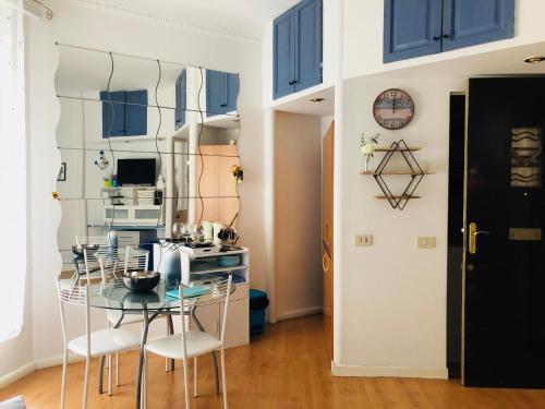 - une salle à manger avec des armoires bleues, une table et des chaises dans l'établissement 10 Rue Verdi, à Nice