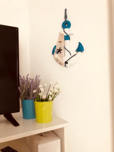 une horloge sur un mur à côté d'un bureau avec des fleurs dans l'établissement 10 Rue Verdi, à Nice