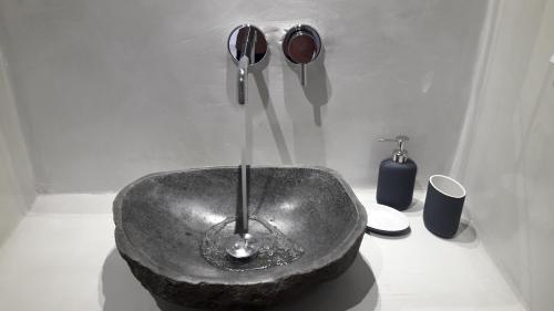 a bathroom with a stone sink with a faucet at Maistrali Prive in Karterados