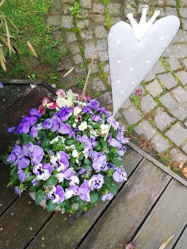 a bouquet of purple and white flowers next to a white heart at idylische Ferienwohnung in Schollbrunn