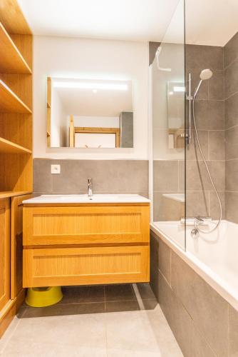 une salle de bain avec un lavabo et une douche dans l'établissement Apt. Grand Paradis B14 - Modern with Mont Blanc view, à Chamonix-Mont-Blanc