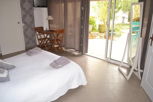 ラ・キャディエール・ダズールにあるChambre d'hôtes La Cadière d'Azurのベッドルーム1室(白いベッド1台、タオル付)