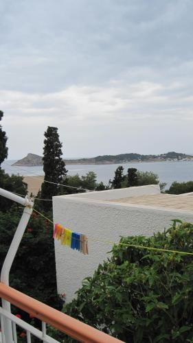 a string of flags hanging on a fence overlooking the water at Tatsis Apartments in Masouri