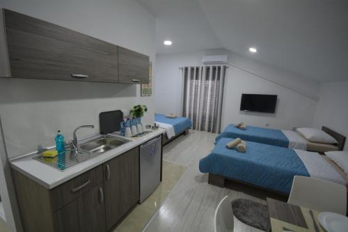 cocina y sala de estar con 2 camas en Luna Apartments Gevgelija, en Gevgelija