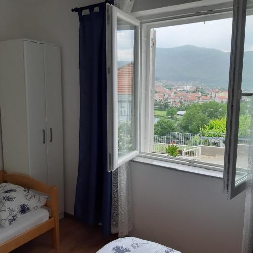 a bedroom with a window with a view of a city at Nijona 1 in Trebinje