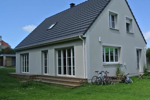 a white house with two bikes parked in the yard at Homes d opale, Caroline in Saint-Martin-Boulogne