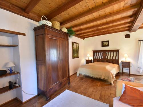 a bedroom with a bed and a large wooden cabinet at Saint-Sauveur Hideaway in Saint-Michel-de-la-Pierre