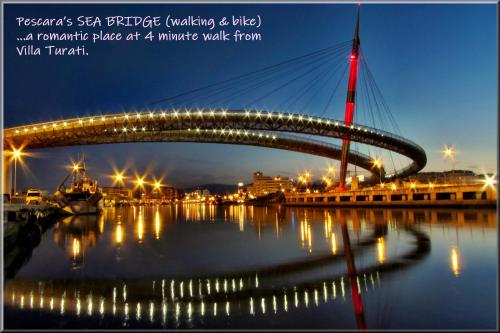 a bridge over a river at night with lights at Villa Turati in Pescara