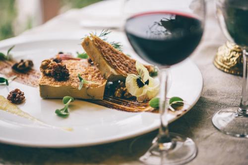 a plate with a piece of cake and a glass of wine at Gran Hotel Balneario De Puente Viesgo in Puente Viesgo