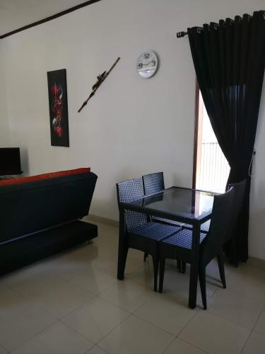 a black table and chairs in a room with a window at Dream Estate Resort in Senggigi 