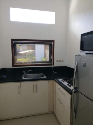 a kitchen with a sink and a stove and a window at Dream Estate Resort in Senggigi 