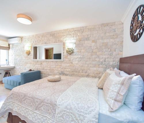 um quarto com uma cama e uma parede de tijolos em Old Town Skyline apartment 3 em Budva