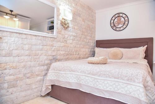 a bedroom with a brick wall and a bed at Old Town Skyline apartment 3 in Budva