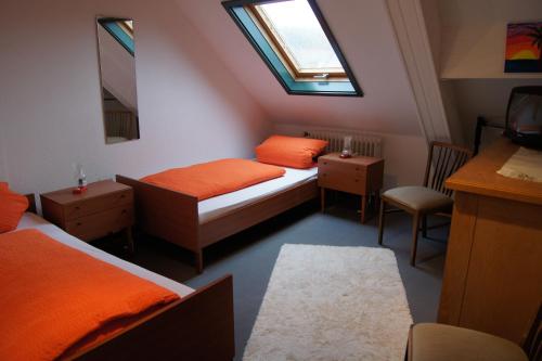 a small bedroom with two beds and a window at Pension Loni Theisen in Kelberg