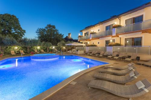 a swimming pool with lounge chairs next to a building at Hotel Porta Rosa in Ascea