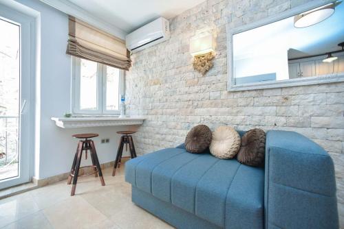 a blue couch in a room with a brick wall at Old Town Skyline apartment 3 in Budva