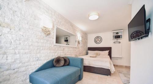 a living room with a blue couch and a bed at Old Town Skyline apartment 3 in Budva