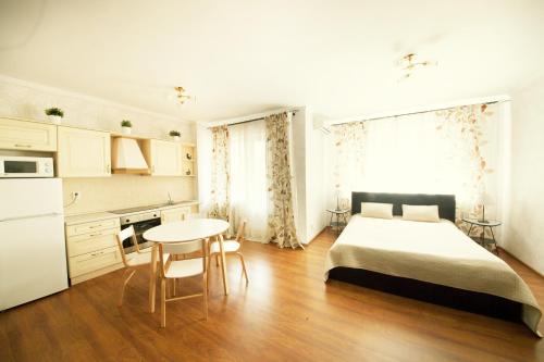 ロストフ・ナ・ドヌにあるKvartirkino-2 Apartmentsのベッドルーム1室(ベッド1台、テーブル付)、キッチン