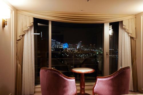 a room with a window with a table and chairs at Hotel New Grand in Yokohama