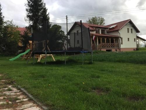a playground in a yard with a house at Bajanówka in Jazowa