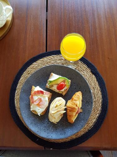 a plate with three sandwiches and a glass of orange juice at Maison 66, Riviera Hotels in Athens