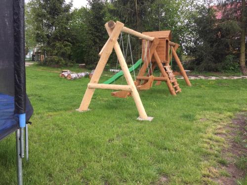 a playground with a swing set in the grass at Bajanówka in Jazowa