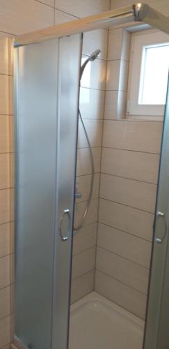 um chuveiro com uma porta de vidro na casa de banho em Studio Apartmani Šehić em Krvavica