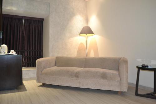 a living room with a couch and a lamp at Southern Plaza in Kolkata