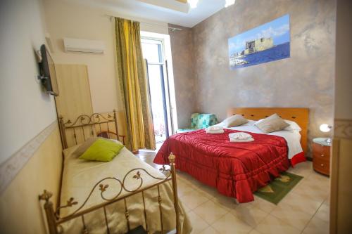 - une chambre avec 2 lits et une couverture rouge dans l'établissement Benvenuto a Napoli, à Naples