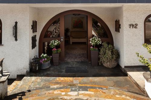 an entrance to a house with potted plants on the floor at Hotel Petra in Baiersbronn